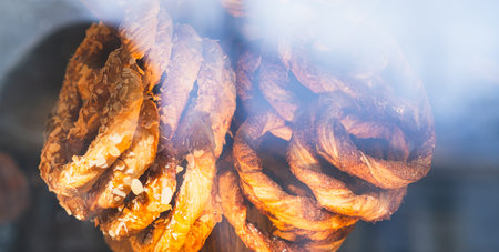 Delicious almond pretzel twists in a bakery display. Sweet pastry baked golden brown. Freshly baked dessert for snack or breakfastの写真素材