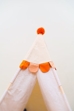 Children play tent with an orange pompom top and scalloped trim. Cozy indoor play space for kid...