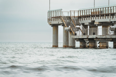 Pier with concrete pillars extending into the sea for transportation structure. Coastal engineering and marine architecture conceptの写真素材