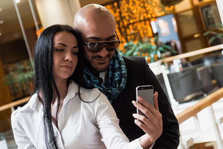 Arab businessman and girl making selfie in the shopping centerの写真素材