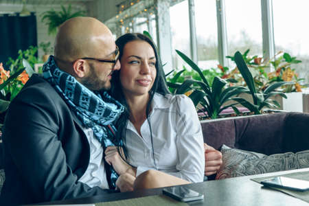 Arab man sits, hugs a beautiful girl in the restaurantの写真素材