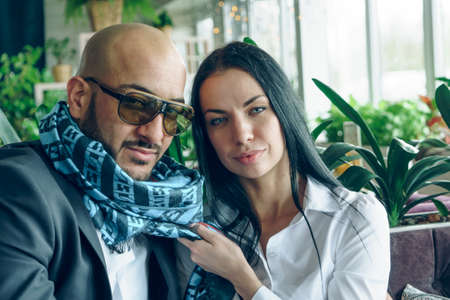 Arab man sits, hugs a beautiful girl in the restaurantの写真素材