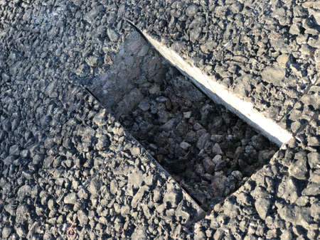 Place of sampling the asphalt coating in the form of a rectangular from asphalt concrete pavement. Kern. Close-upの写真素材