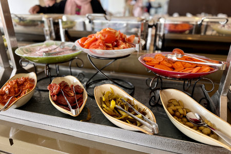 Fresh carrot, red tomatoes cut into slices other salads in a beautiful bowls for buffet meals in a restaurant. Vegetables on a plate. Close-upの写真素材