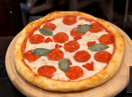 Top view of delicious sliced pepperoni pizza on wooden dish on the table at the restaurant. Close-upの写真素材