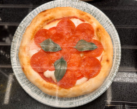 Top view of delicious sliced pepperoni pizza on wooden dish on the table at the restaurant. Close-upの写真素材