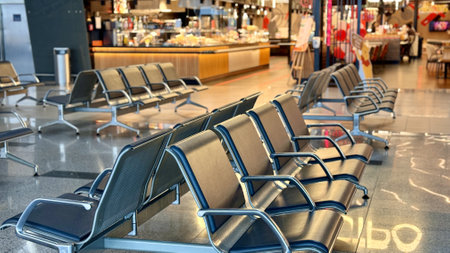 A row of stainless steel chairs in the station waiting area, each one filled with leatherette for sitting. The handrails are made of metal and steel, adding engineering touch to rectangular designの写真素材