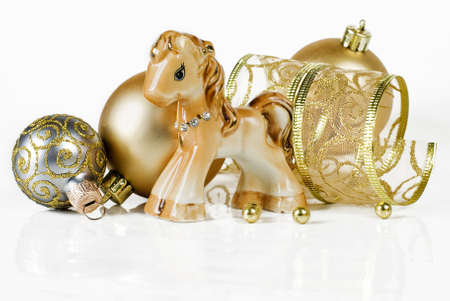 Christmas composition with a toy horse and a gold Christmas ballsの写真素材