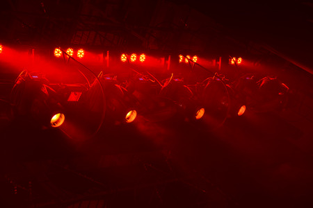 Powerful spotlights illuminate the scene with red light