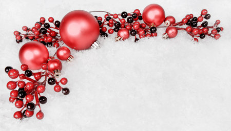 Reds Christmas balls and holly berries on white snowの写真素材