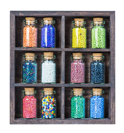 Small bottles with colored beads in old wooden boxの写真素材