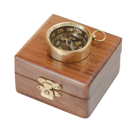 Ancient compass on a wooden case isolated on white backgroundの写真素材