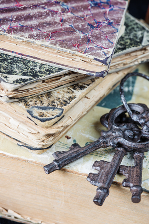Vintage metal keys and the old books covered with shabby hardcoverの写真素材
