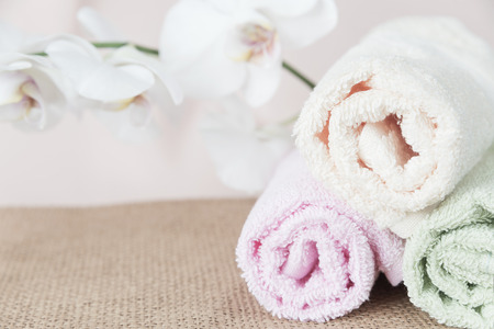 Spa concept: bath towels and a branch of white orchid, with space for textの写真素材