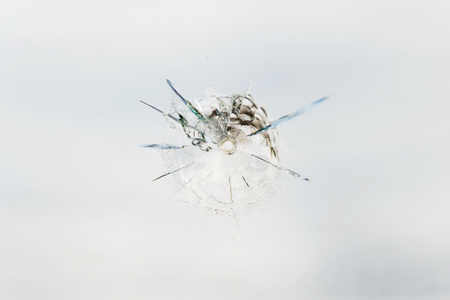 Round bullet hole in the glass with radial cracksの写真素材