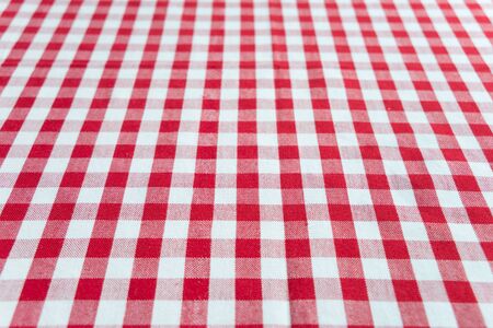 Table perspective view covered by cotton checked red and white tablecloth