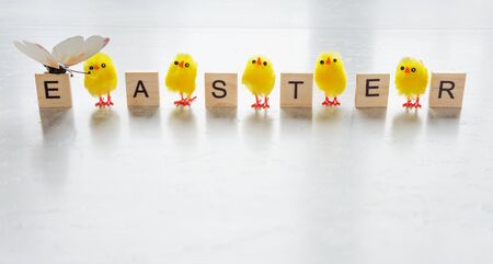 Easter concept: inscription Easter, consisting of wooden game pieces with letters, and yellow furry...