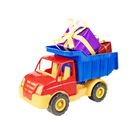 Multicolored plastic toy truck carries gift boxes tied with decorative ribbons in body,  isolated on white backgroundの写真素材