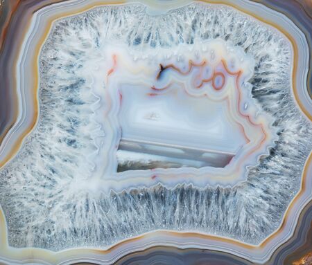 Thin slice of multicolor lacy agate geodes with concentric layers close-up