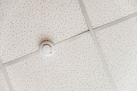 Smoke detector of fire alarm on the background of a white ceilingの写真素材