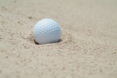 Golf-ball in bunker. Shallow depth of field.の写真素材