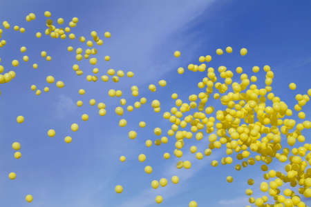 Yellow balloons on a blue sky backgroundの写真素材