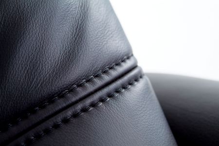 Seam on black leather furniture with white background. Shallow depth of fieldの写真素材