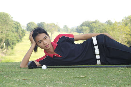 Young, female, Asian golf player resting at the tee-boxの写真素材