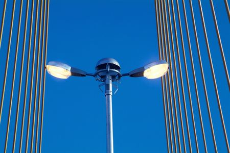 Street light on suspension bridge with yellow cablesの写真素材