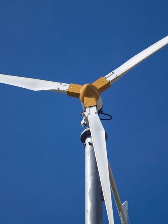 Detail of small, white wind generator against a blue sky