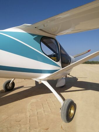 Light airplane parked on a dirt airfield