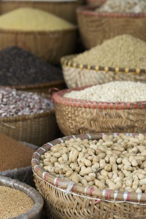 Assortment of beans and seeds in baskets at a market. Photo taken in Hanoi, Vietnam. Shallow depth of field with the peanuts in the front in focus.の写真素材