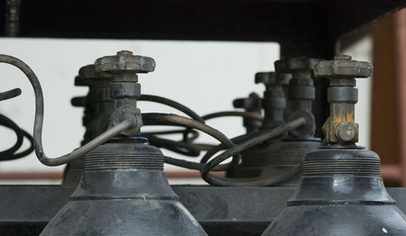 Battery of old gas bottle with only the tops and the valves of the bottles visible. Shallow depth of field with the nearest bottles in focus.の写真素材