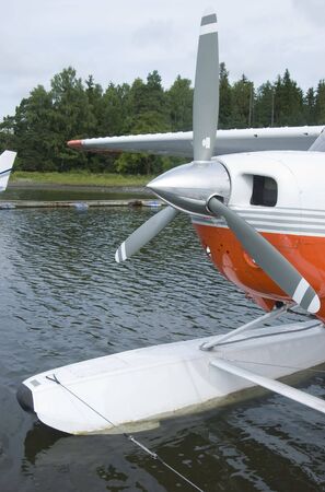Front detail of moored orange and white seaplane