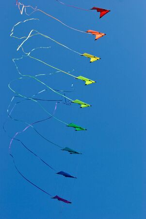 Stack of stunt kites in rainbow colours. Tails are slightly blurred from fast movement.の写真素材