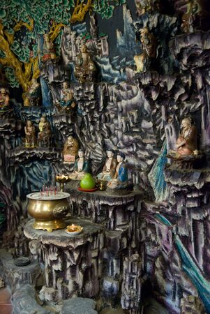 Cave-like interior at Hau Wong Temple in Hong Kong. Shallow depth of field with the central Buddha images in focus.の写真素材
