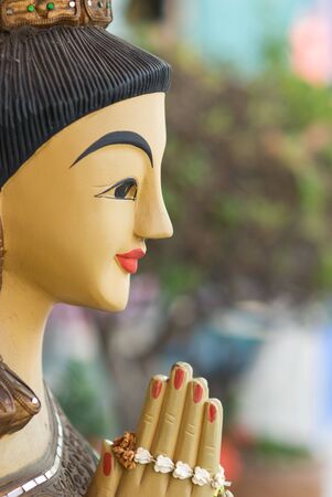 Wooden sculpture of a woman, wishing people welcome to a shop in Thailand.の写真素材