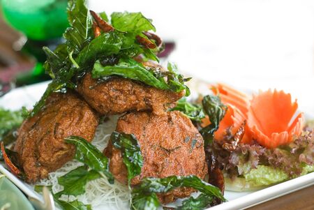 Tod Man Pla, Thai fish cakes. Shallow depth of field, partly isolated on white.