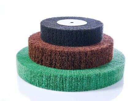 Three abrasive wheels in the colours green, red and black with reflection, isolated on white.の写真素材