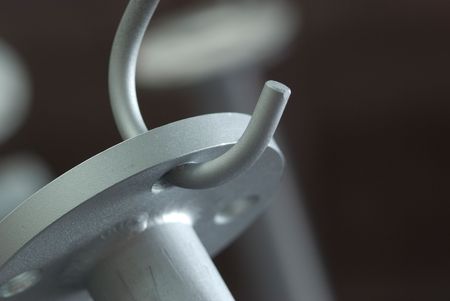 Pipe with flange left for drying at an industrial paint shop. Very shallow depth of field with only the main subject in focus.の写真素材