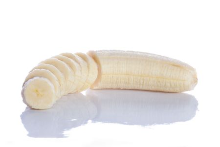 Peeled, sliced banana with reflection, isolated on white.の写真素材