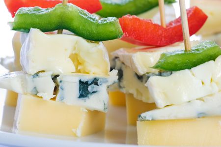 Cheese snacks with three kinds of cheese and pieces of capsicum. Shallow depth of field, with the snack to the left in focus.の写真素材