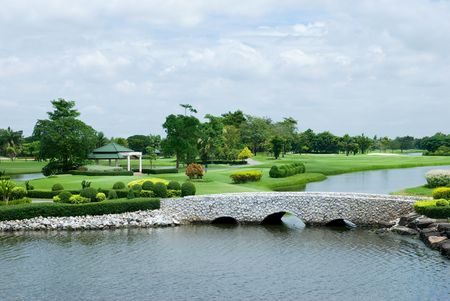 Beautiful golf course with water and a stone bridge. Photo taken in Bangkok, Thailand.の写真素材
