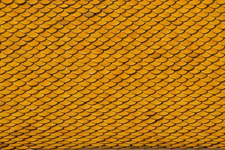 Yellow, tiled roof of a Buddhist temple in Bangkok, Thailandの写真素材