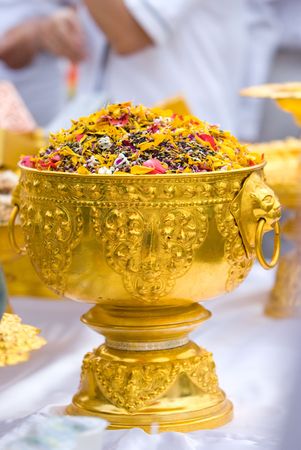 Dried flower petals in a golden bowl at a Buddhist ceremony in Thailand. Shallow depth of field.の写真素材