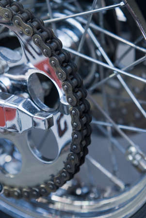 Close-up of chain on heavy motorbike with many chrome parts. Very shallow depth of field with top half of the chain in focus.の写真素材