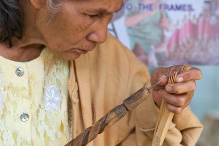 CHIANG MAI, THAILAND - JANUARY 15: Woman demonstrating traditional umbrella-making during the annual Umbrella festival in Chiang Mai, Thailand on January 15, 2010. The festival is held in Bo Sang, where traditional umbrellas have been made for more than 1のeditorial素材
