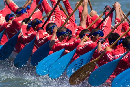 Pattaya, Thailand, Saturday 21 November 2009: The annual longboat races were arranged at the Maprachan Lake. The most spectacular class was the 55 man longboat, with teams from all over the nation. Shallow depth of field with the nearest paddlers in focusのeditorial素材