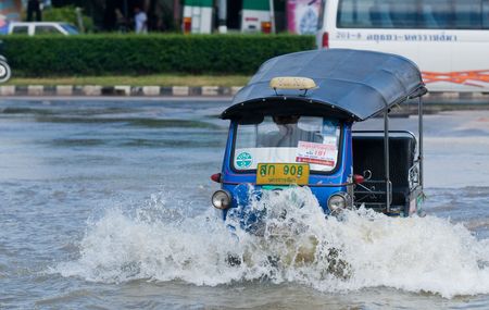 NAKHON RATCHASIMA - OCTOBER 24: Tuk-tuk taxi in deep water during the monsoon flooding of October 24, 2010 in Nakhon Ratchasima, Thailand.のeditorial素材