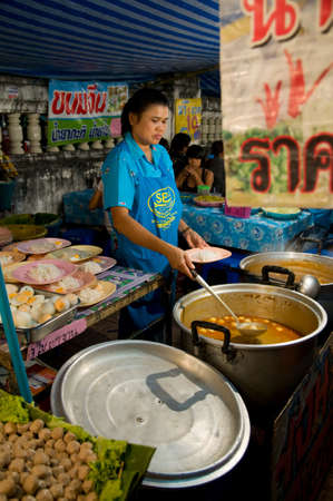 SAMUT PRAKAN - NOVEMBER 7: Woman selling Kanom Jeen in an improvised restaurant at Pra Samut Chedi temple fair on November 7, 2010 in Samut Prakan, Thailand.のeditorial素材
